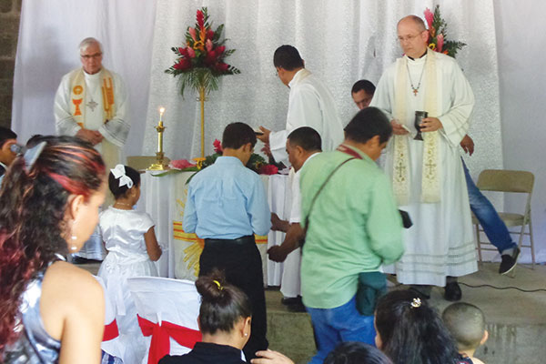 Rev. Robert Krestick (Redeemer, Waterloo, Ontario) and Rev. Richard Frey (St. Paul's, Elmira, Ontario) distribute Holy Communion at the church dedication in Telica.  In the middle, turned away from the camera, is former Nicaraguan synodical president Rev. Luis Antonio Diaz Turcio.
