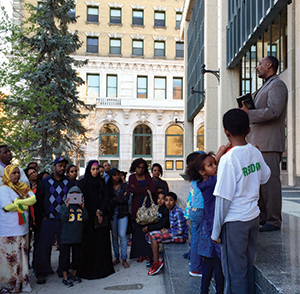 Rev. Asefa Aredo (far right) addresses the Oromo community during a candlelight vigil at Winnipeg's City Hall.